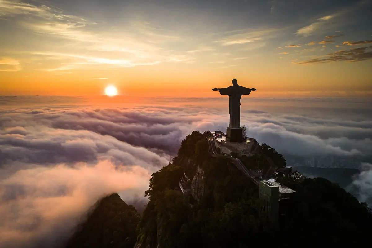 Christ the Redeemer above a sea of clouds at sunrise