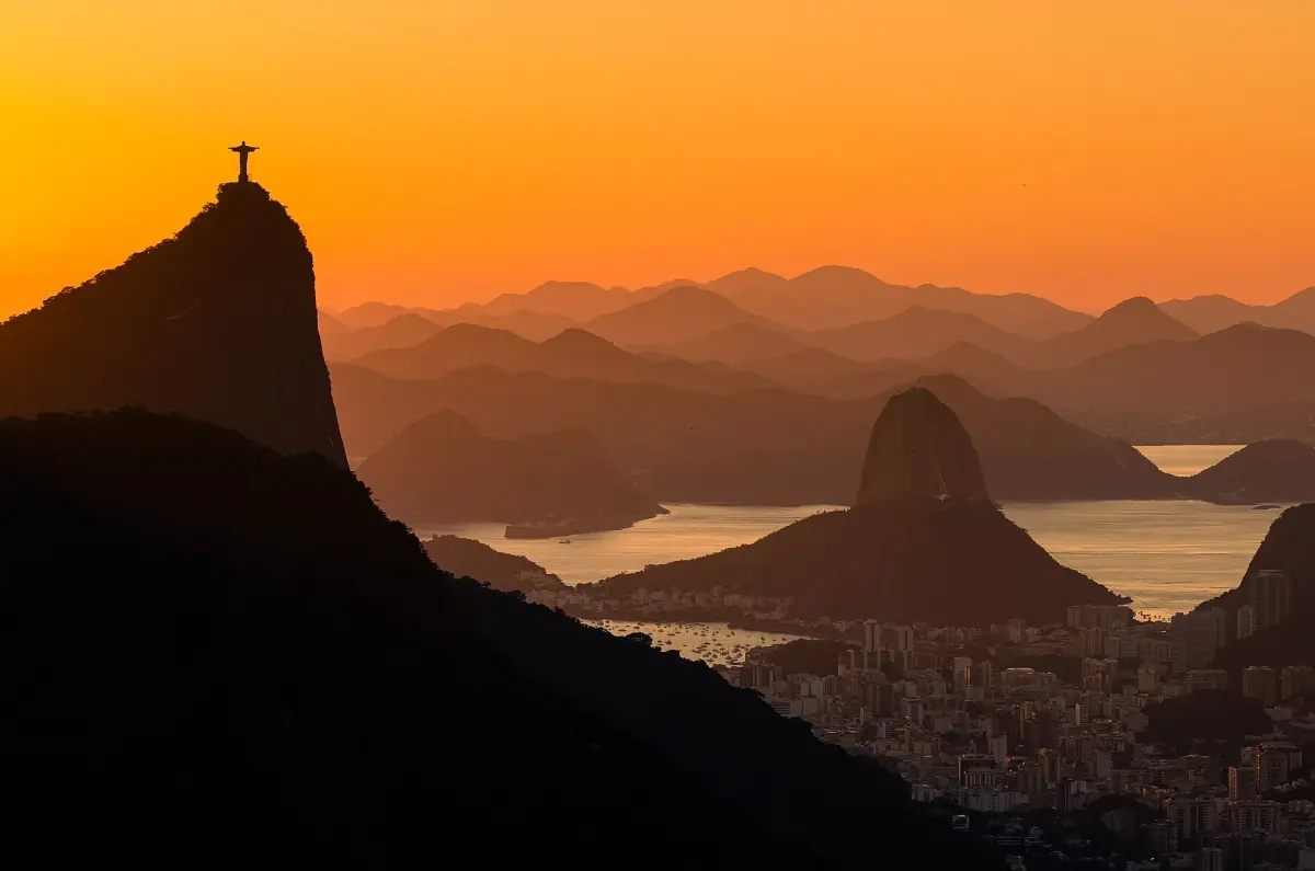 Silhouette of Corcovado and the statue at sunset over the bay